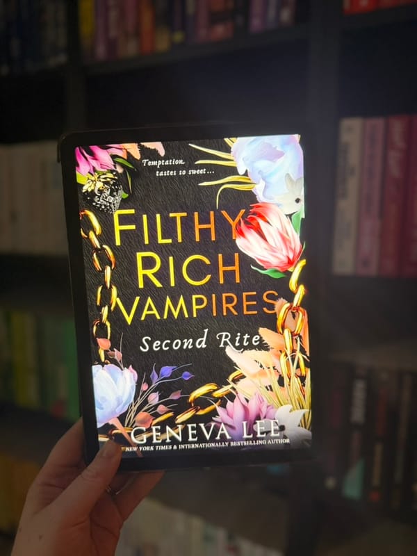 A hand holds a tablet displaying the cover of Second Rite, the second Filthy Rich Vampires book by Geneva Lee.